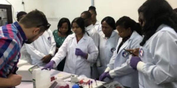 Scientists in lab coats working together on an experiment.