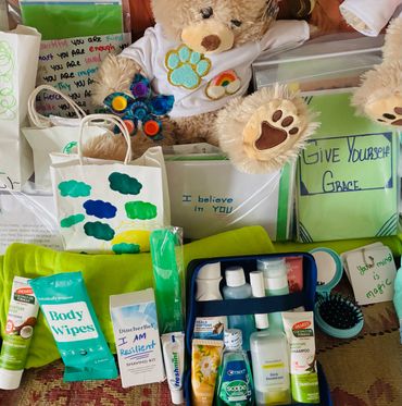 Care package with toiletries, motivational notes, and teddy bears.