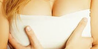 Woman holding her breasts after breast reduction surgery