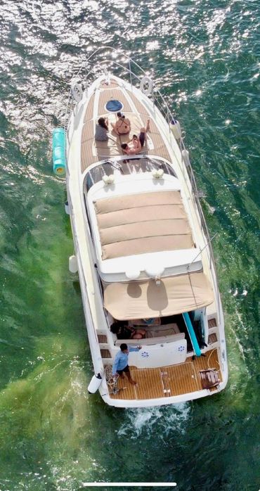 Overhead view of a boat with people enjoying a sunny day on the water.
