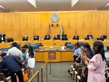 Clark County government meeting with officials seated and attendees in the foreground.