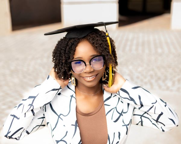 Happy graduate wearing a cap and glasses.