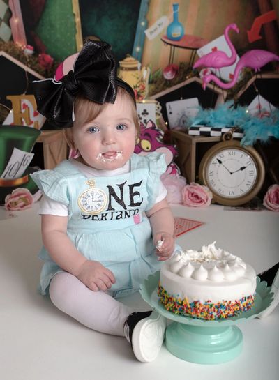 Alice in Wonderland cake smash, enjoying her birthday cake!