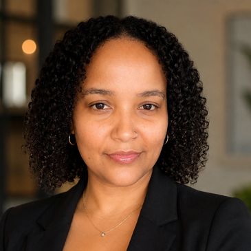 Portrait of a woman with curly hair and a black blazer.