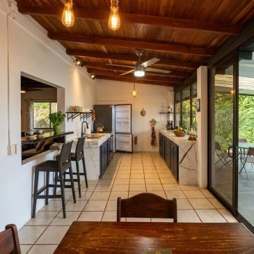 Cozy kitchen with wooden ceiling and large sliding glass doors.