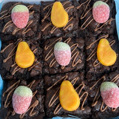 Chocolate brownies topped with colorful gummy candies and drizzled chocolate.