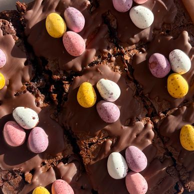 Close-up of chocolate brownies topped with colorful candy eggs.