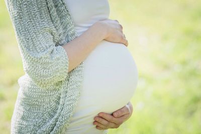 Woman holding pregnant stomach