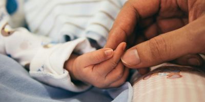Baby hand held by mother