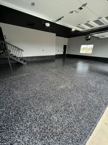 Newly coated speckled epoxy floor in a clean, spacious garage.