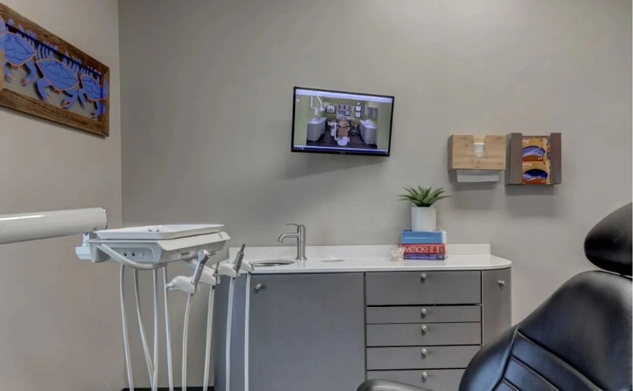 Modern dental office with equipment and TV.