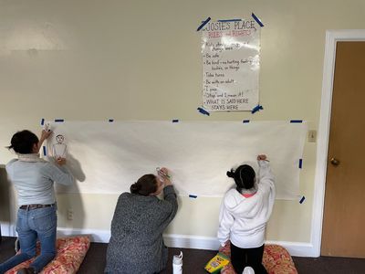 facilitators and group members creating a mural