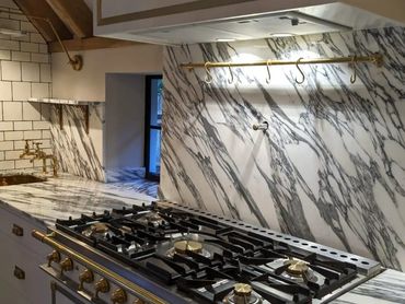 Elegant kitchen with marble countertops and gold fixtures.
