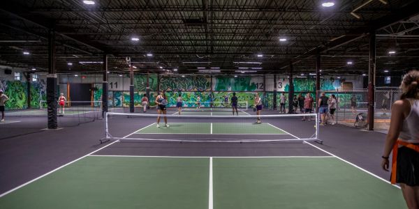 Indoor pickleball courts with players.