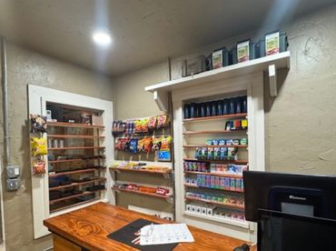 Interior of a small retail checkout counter with snack and tobacco displays.