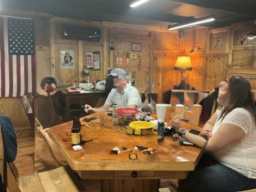 Friends relaxing together around the poker table in the lounge at Mystery Shack Cigars & Coffee.