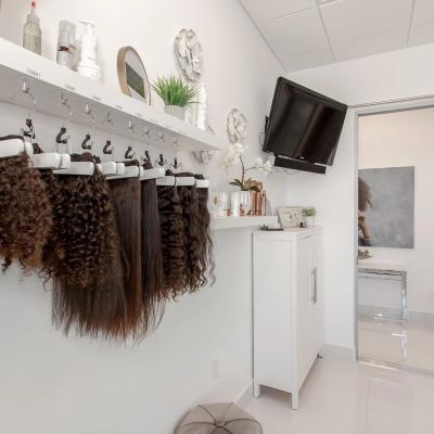 Hair extensions hanging on hooks in a modern salon room.