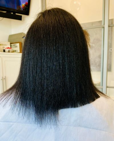 Back view of a person with straight, shoulder-length black hair.