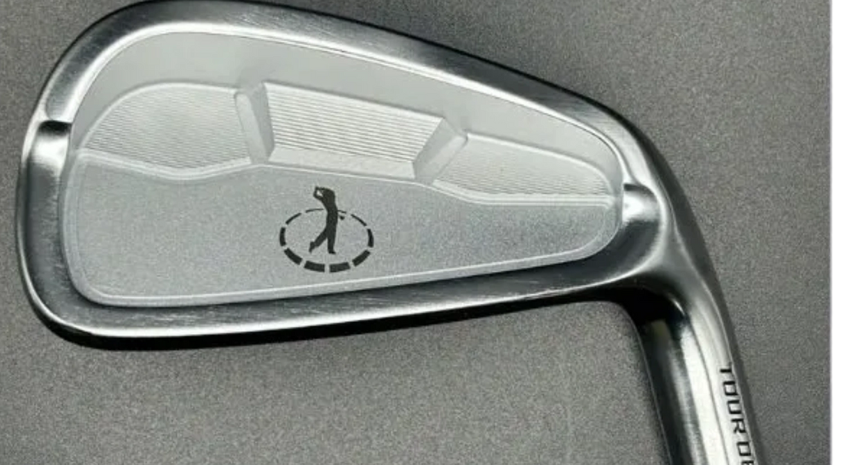 Close-up of a golf iron club head with a golfer logo.