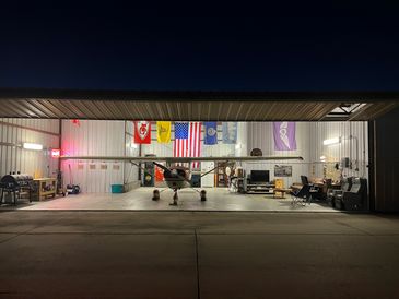 Small airplane inside a hangar at night.