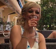 Woman holding a glass and smiling.