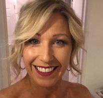 Smiling woman with blonde hair and red lipstick.