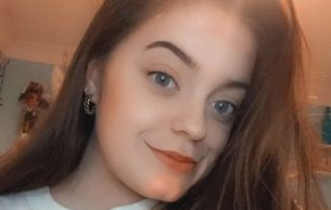 Close-up of a young woman smiling.
