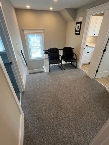Cozy upstairs landing with two chairs and neutral decor.