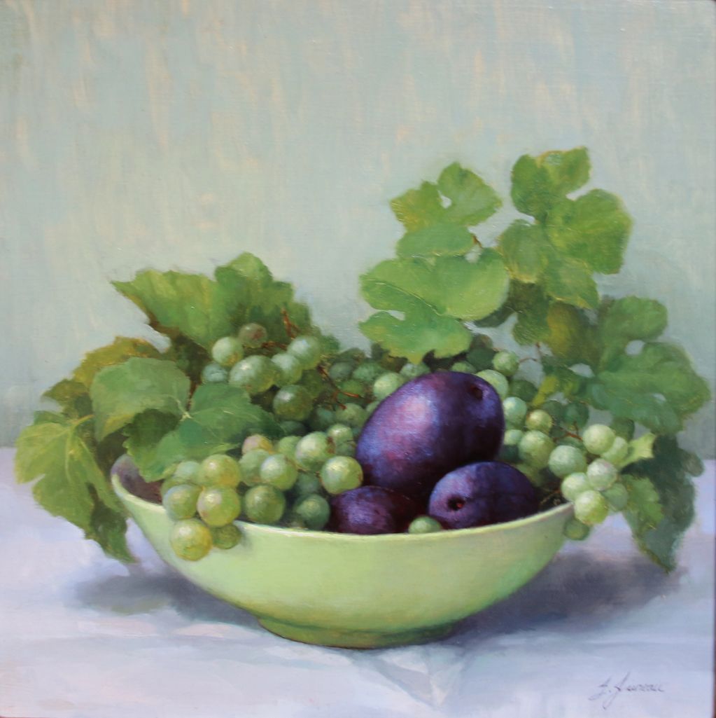Plums and grapes in a green bowl