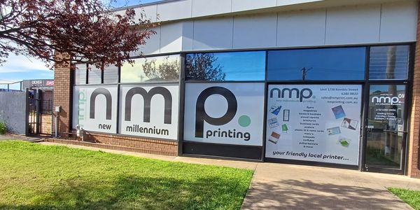 Exterior of New Millennium Printing shop with large signage and contact details.
