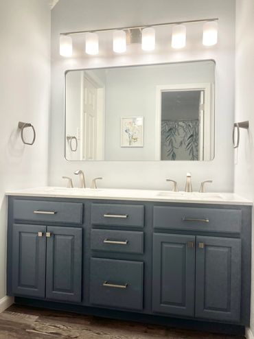 remodeled custom bathroom with navy blue double vanity, bright lighting, quality interior painting