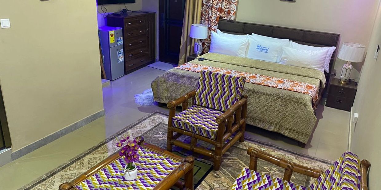 Cozy hotel room with patterned furniture and a large bed.