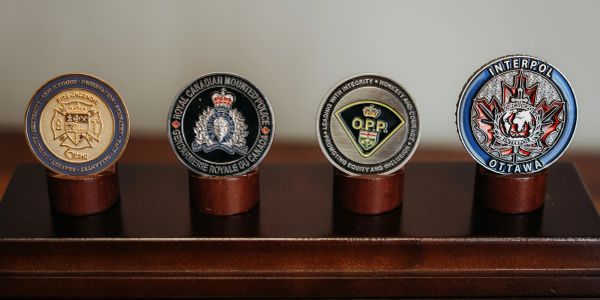 Four police challenge coins on display stands.