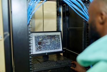 Person analyzing a satellite image on a computer in a server room.