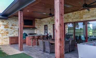 An outdoor kitchen and living area with furniture
