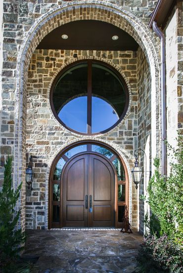 A dome entryway and a big, round glass window above the door