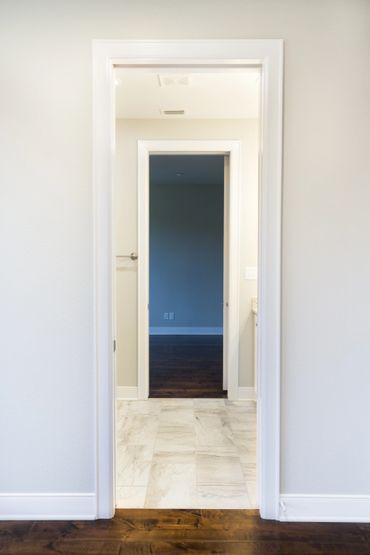 A hallway that passes into a room