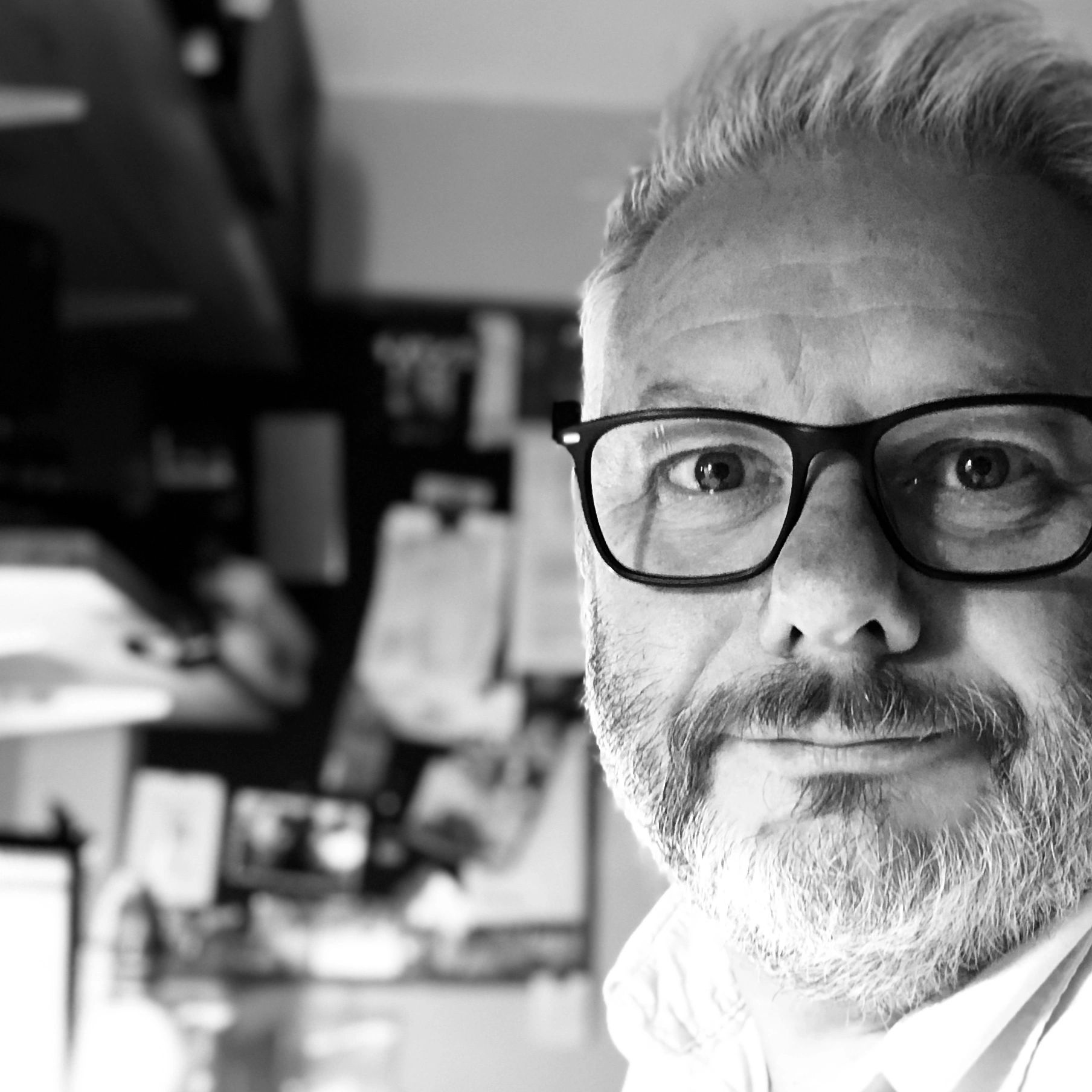 Close-up portrait of a middle-aged man with glasses and a beard.