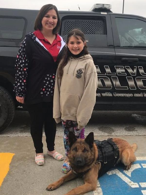 Izzy and Brandi posing with Max as he shows off his donated safety vest!
