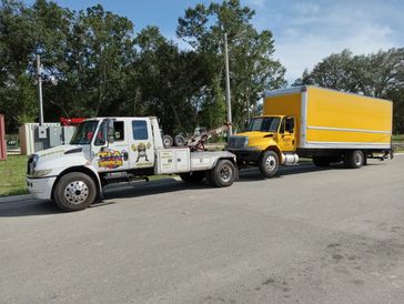 tow truck towing a box truck