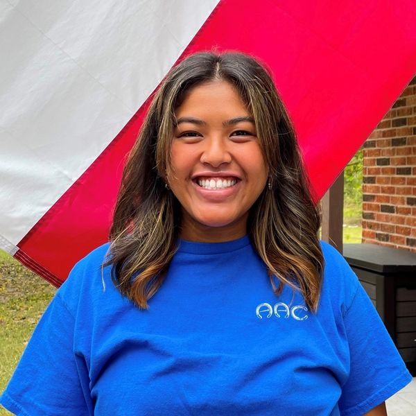 Katie standing in front of a Texas flag