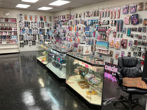 Interior of an adult store with various products displayed on walls and glass cases.