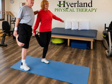 Senior man and woman stretching in a physical therapy clinic.