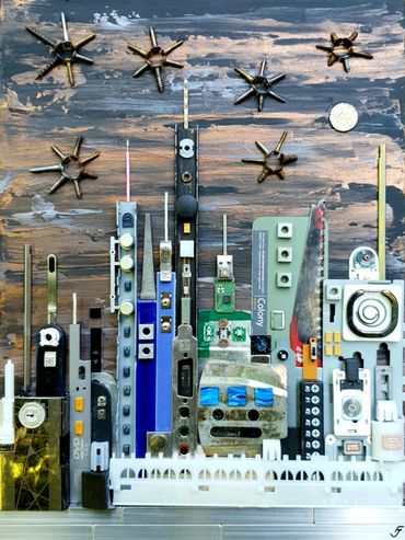 Alien Colony A gold, bronze & black painting with found metal & plastic objects creating a cityscape
