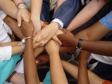 Diverse hands joined together in unity and teamwork.