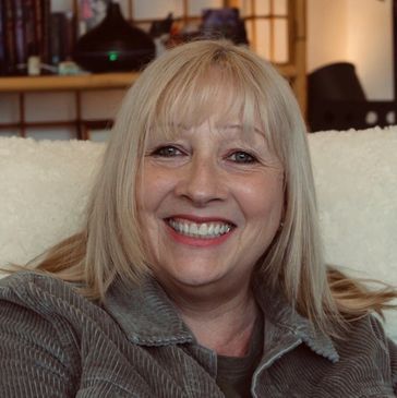 Smiling middle-aged woman with blonde hair.
