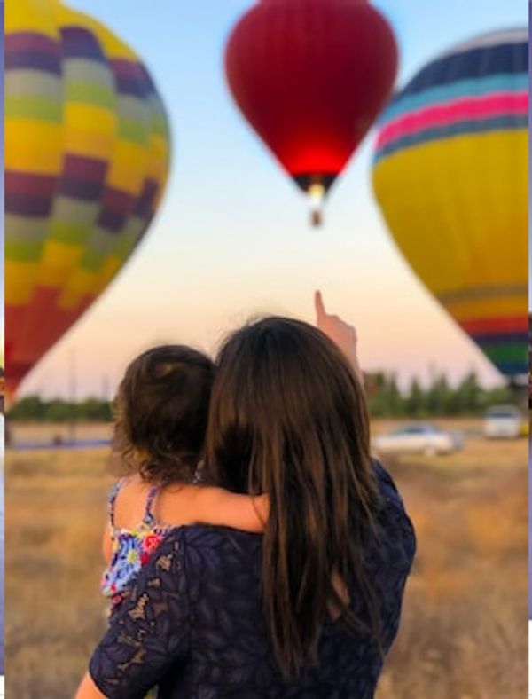 Mother and child looking at hot air balloons- being a mother broadens my skill set.