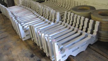 Stacked foam corner protectors and round foam cushions on a wooden surface.