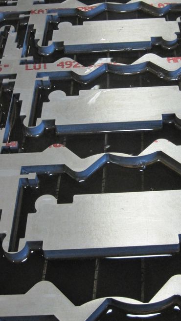 Metal parts arranged in a grid-like pattern with reflective surfaces.