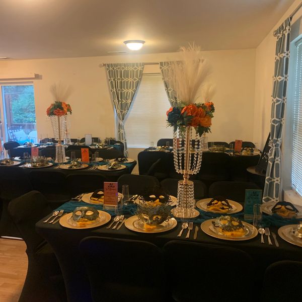Elegant dining setup with black tablecloths and floral centerpieces.